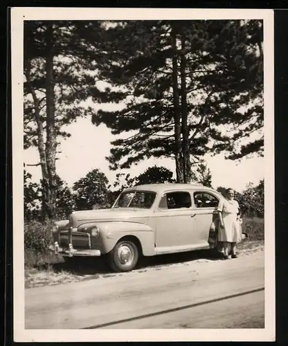 Fotografie Auto Ford, US-Car, Hausfrau neben Limousine stehend