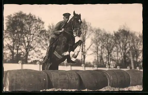 Foto-AK Soldat auf einem Pferd beim Überspringen einer Hürde aus Fässern