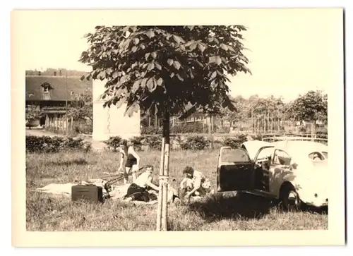 2 Fotografien Auto VW Brezel Käfer, Volkswagen auf dem Weg neben einem Campingplatz / Zeltplatz