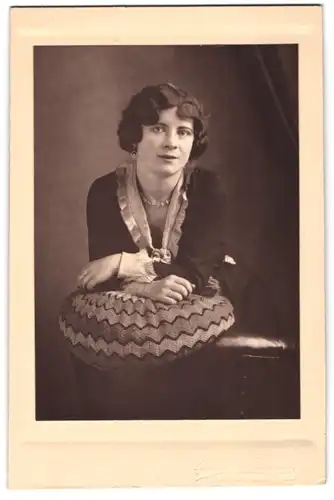 Fotografie Rudolf Meyer, Bremen, hübsche junge Dame im dunklen Kleid mit Ohrringen und Perlenhalskette