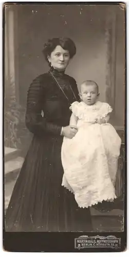 Fotografie Martin Balg, Berlin, Königstr. 33, junge Mutter im dunklen Kleid mit ihrem Kind im Taufkleid