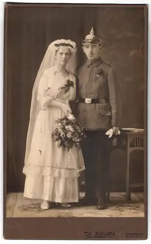 Fotografie Dietrich & Witte, Chemnitz, junger Soldat in Uniform mit Pickelhaube nebst seiner Braut, Kriegshochzeit