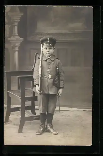 Foto-AK Kind in Uniform mit Säbel und Gewehr, Kinder Kriegspropaganda