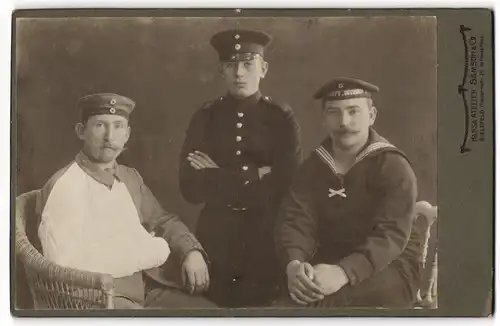 Fotografie Samson & Co., Bielefeld, Matrose der Werft Division mit Soldat in Uniform Rgt. 7 und verwundetem Soldaten