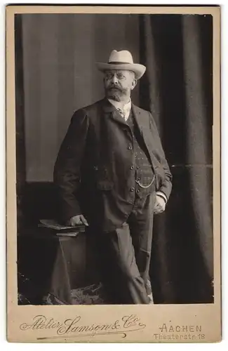 Fotografie Samson & Co., Aachen, Theaterstr. 18, Herr Oswald Küpper im Anzug mit Zwickerbrille und Hut, 1906