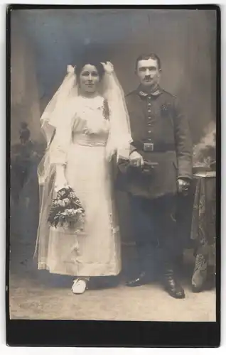 Fotografie Herm. Schmidt, Olbernhau i. Sa., Soldat in Feldgrau Uniform nebst seiner Braut, Kriegshochzeit