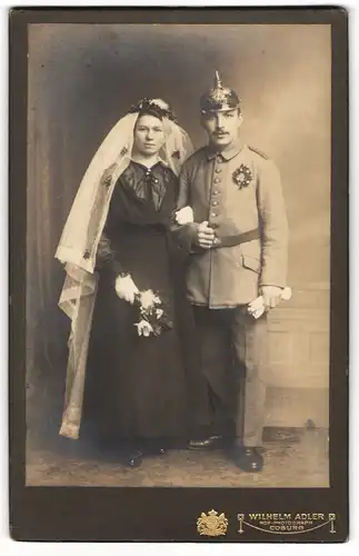 Fotografie Wilhelm Adler, Coburg, Einjährig-Freiwilliger in Uniform mit Picklehaube nebst seiner Braut, Kriegshochzeit