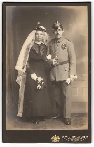 Fotografie Wilhelm Adler, Coburg, Einjährig-Freiwilliger Soldat mit Pickelhaube nebst seiner Braut, Kriegshochzeit