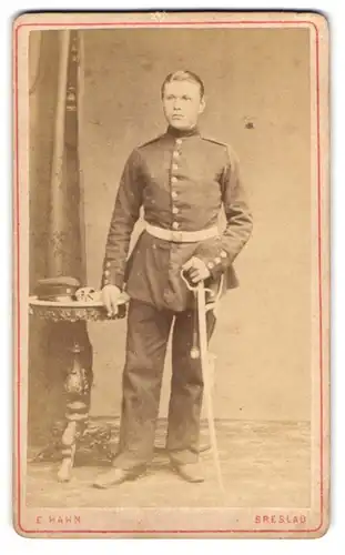 Fotografie E. Hahn, Breslau, junger Soldat in Uniform mit Säbel posiert im Atelier