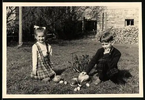 Fotografie Meffert, Hildburghausen, Ostern, Mädchen und Knabe auf der Suche nach Ostereiern 1957