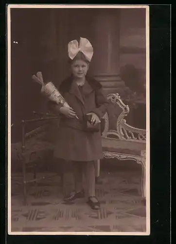 Foto-AK Mädchen mit Zuckertüte und Schleife im Haar, Schulanfang