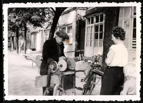 Fotografie Fotograf unbekannt, Messerschleifer arbeitet am Schleifbock Besteckteile auf