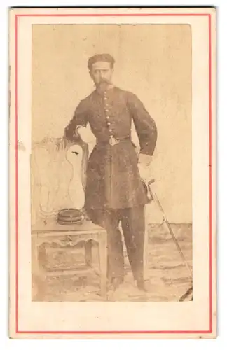 Fotografie unbekannter Fotograf und Ort, Soldat Juan Barrios Mendoza in Uniform mit Säbel, 1870