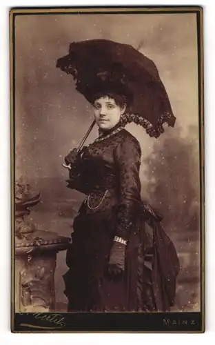 Fotografie Hertel, Mainz, Portrait junge Frau im dunklen taillierten Kleid mit Sonnenschirm und Hut