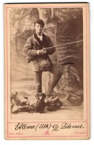 Fotografie Carl Remde, Eisenach, junger Jäger Etllmer mit seinem Dackel und Flinte posiert im Atelier