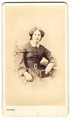 Fotografie T. W. Hermann, Hamburg, Portrait junge Dame im seidenen Kleid mit Brosche