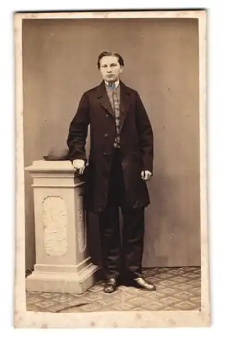 Fotografie M. Redwitz, Neustadt a. S., junger Mann im dunklen Anzug mit Hut neben sich