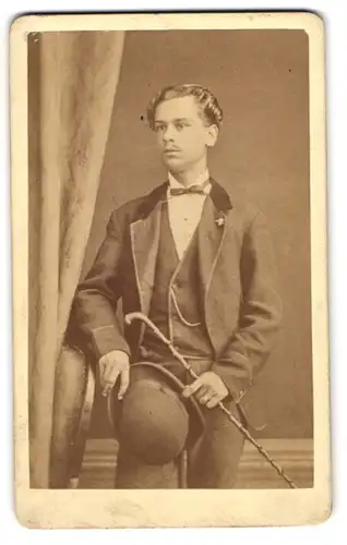 Fotografie Anton Fischer, Coburg, Portrait junger Mann im Anzug mit Fliege und Melone samt Flanierstock