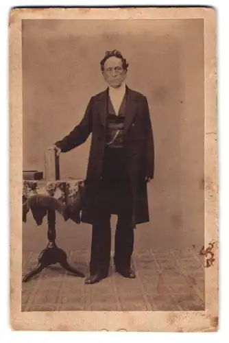 Fotografie Louis Döring, Carlsruhe, älterer Herr im Anzug mit Fotoalbum im Atelier