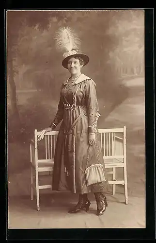 Foto-AK Lächelnde Dame an einer Bank, vor einer Studiokulisse