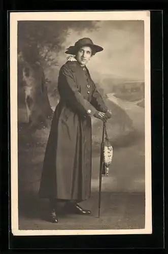 Foto-AK Frau im Mantel mit Schirm vor einer Studiokulisse