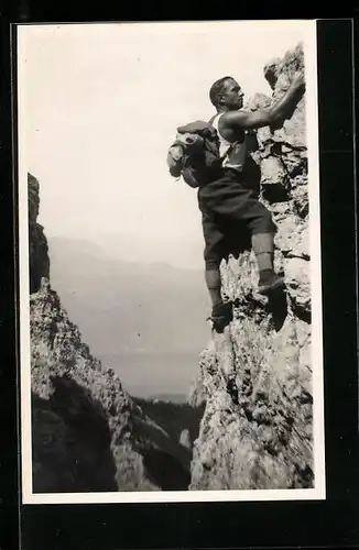 Foto-AK Mann hängt an Feldklippe, Bergsteigen