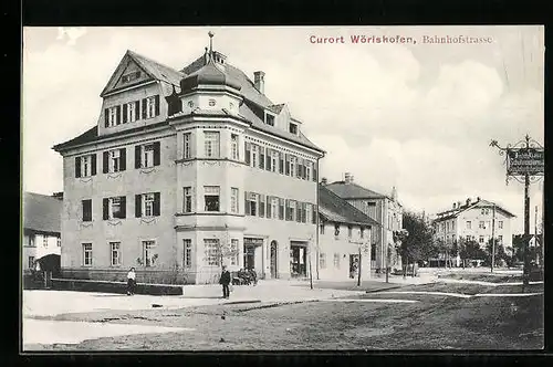 AK Wörishofen, Partie in der Bahnhofstrasse, mit markantem Eckgebäude und Schild des Schuhmachers Friedrich Baur