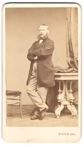 Fotografie M. L. Winter, Prag, Herr im Anzug mit Backenbart und verschrenkten Armen, 1870