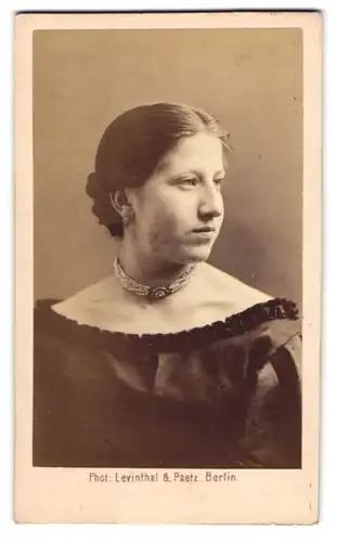 Fotografie Levinthal & Paetz, Berlin, Portrait hübsche junge Frau im im schulterfreien Kleid mit Perlenhalskette