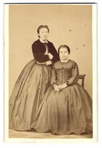 Fotografie J. P. Mahler, Altenbruch, zwei junge Damen in Reifrockkleidern posieren im Atelier