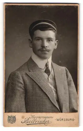 Fotografie Bolbrinker, Würzburg, junger Student im karierten Anzug mit Couleur Mützenband