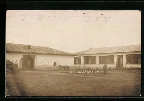 Foto-AK Elmshorn, Soladt in feldgrau Uniform auf dem Hof eines Gutshofes mit Hühnern