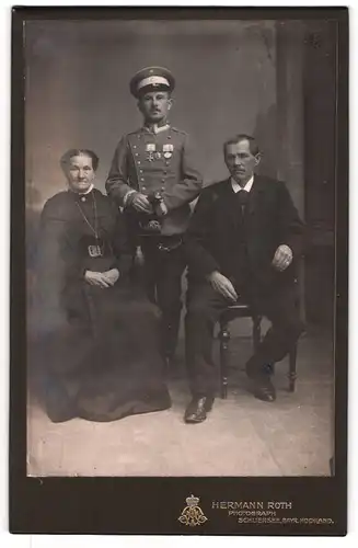 Fotografie Hermann Roth, Schliersee, Uffz. in Uniform mit Bayrischer Ordenspange und Säbel nebst seinen Eltern