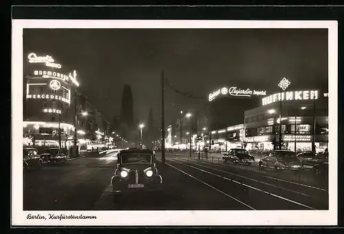 AK Berlin-Charlottenburg, Kurfürstendamm mit Geschäften und Kirche bei Nacht