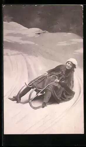 Foto-AK Junge Frau mit Schlitten in der Kurve