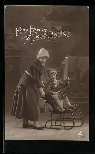 AK Junge auf Schlitten und Frau mit Päckchen, Neujahrsgruss