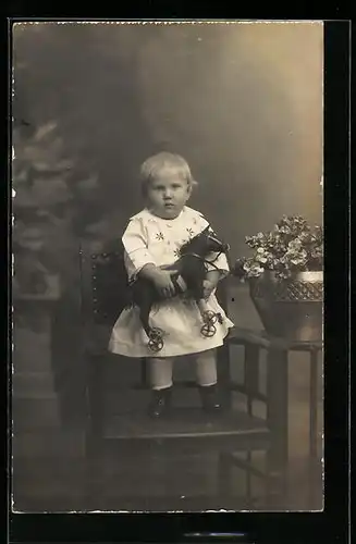 Foto-AK Süsses Kind mit Spielzeugpferd