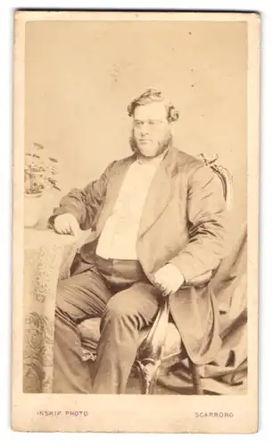 Fotografie Inskip, Scarboro, Beleibter Herr im Anzug sitzt am Tisch