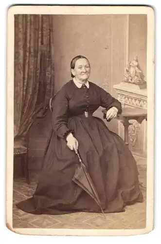 Fotografie Ulr. Güttinger, Winterthur, Am Wildbach 186, Ältere Dame im Kleid mit Schirm