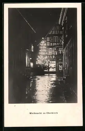 AK Oberkirch, Strassenpartie mit Geschäft und Weihnachtsbaum bei Nacht