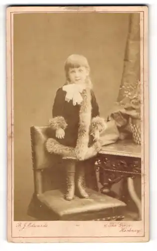 Fotografie B. F. Edwards, London, niedliches englisches Mädchen im Samtmantel stehend auf einem Stuhl