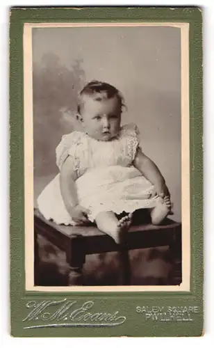 Fotografie W. M. Evans, Pwllheli, niedliches Kleinkind aus Wales im Kleidchen sitztend auf einem Tisch