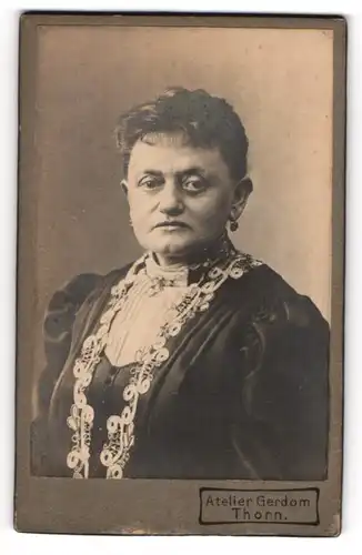 Fotografie Atelier Gerdom, Thorn, ältere Dame im dunklen bestickten Kleid mit Ohrringen