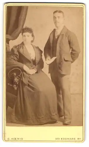 Fotografie C. Koenig, Paddington, englsiches Paar im dunklen Kleid und im Anzug