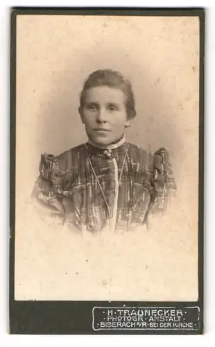 Fotografie H. Taunecker, Biberach a. R., junge Frau im gemusterten Kleid mit Brosche