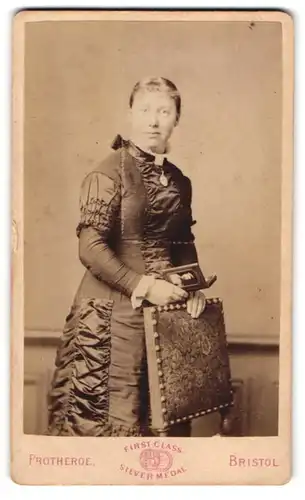 Fotografie Protheroe, Bristol, englische Dame im verzierten Kleid mit Fotografie in der Hand