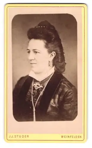 Fotografie J. J. Studer, Weinfelden, Dame im dunklen Kleid mit Halskette und toupierten Haaren
