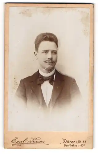 Fotografie Emil Kaiser, Düren / Rhld., junger Mann im Anzug mit Fliege und Moustache