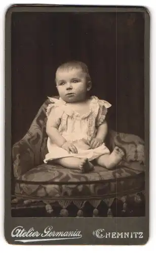 Fotografie Atelier Germania, Chemnitz, niedliches Kleinkind im Kleidchen auf einem Sitzkissen