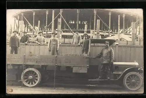 Foto-AK Arbeiter auf einem offenen Lastkraftwagen vor einem Rohbau